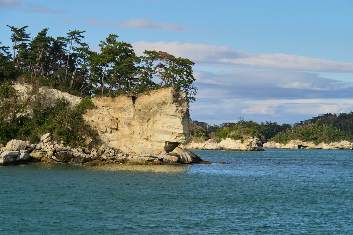 A pine-covered limestone island seen on the bay cruise of a Matsushima bus tour from Sendai