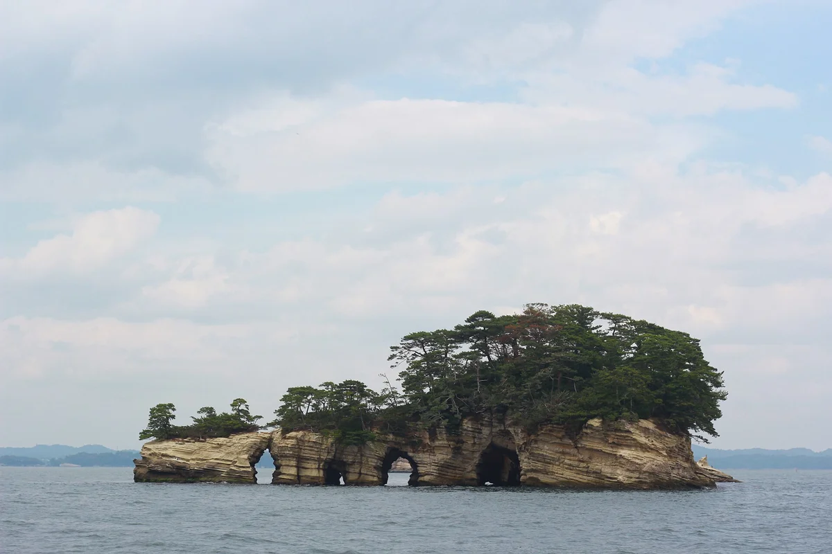 One of the best-known islands of Matsushima Bay with rock arches, seen on a Matsushima tour from Tokyo
