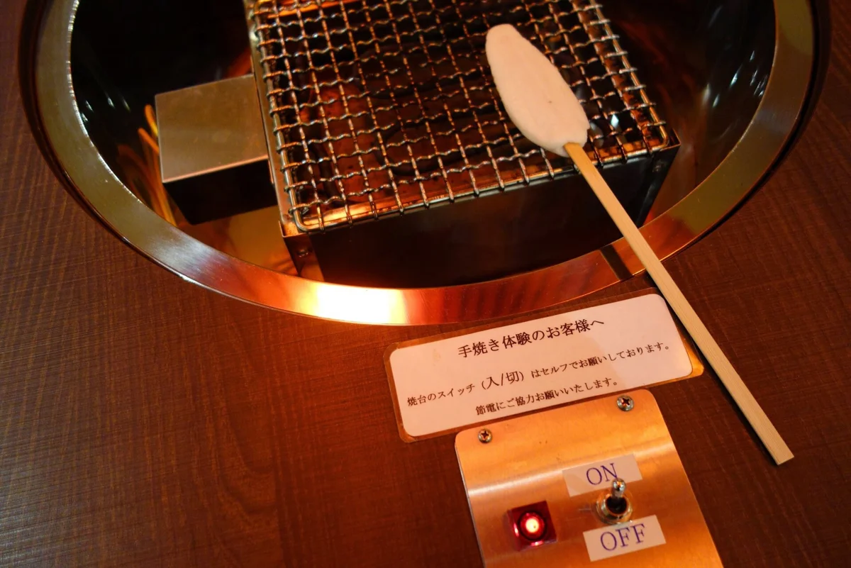 Grilling sasakamaboko fish cake in Matsushima, part of a bus tour from Sendai